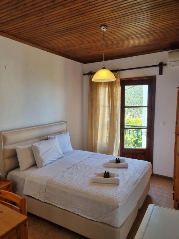 um quarto com uma cama grande com duas toalhas em Zeus Guesthouse em Panagia