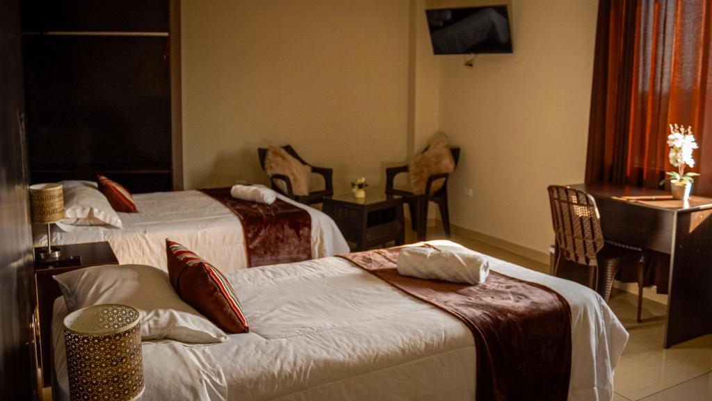 a hotel room with two beds and a table at Hotel Montecristo in Arequipa