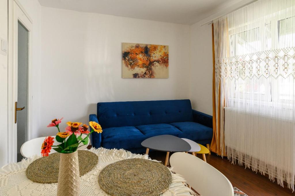 uma sala de estar com um sofá azul e uma mesa em Apartament Corina cu parcare em Bistriţa