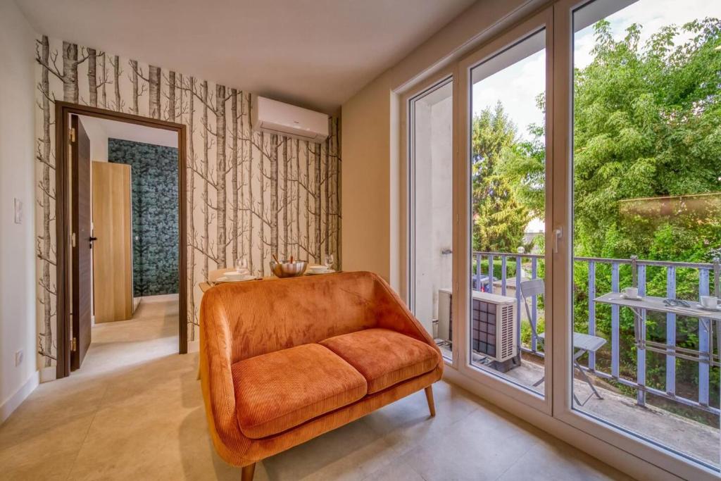 une chaise orange dans une chambre avec balcon dans l'établissement #GS Le Beau Berthelot, à Grenoble