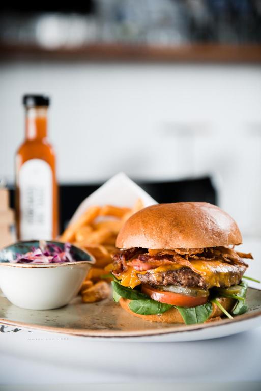 a sandwich on a plate with fries and a sauce at Hotel Daniel Vienna - Smart Lifestyle Near City Centre in Vienna