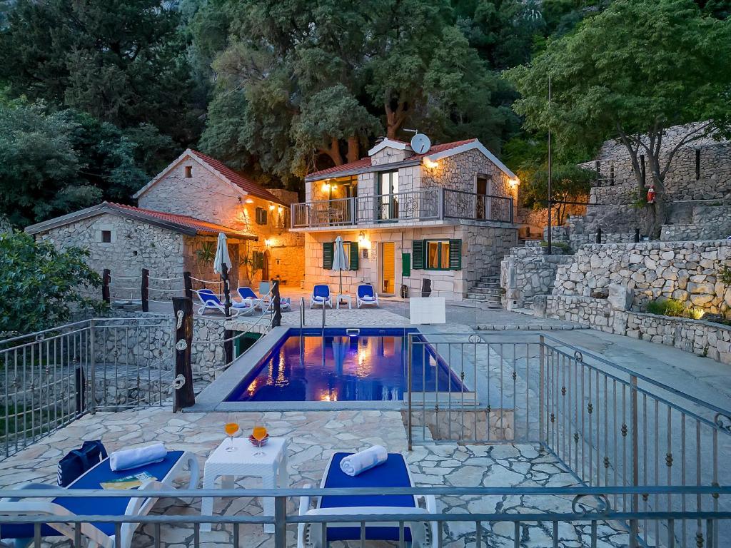 a house with a swimming pool in front of a house at Stonehouse Residence in Makarska