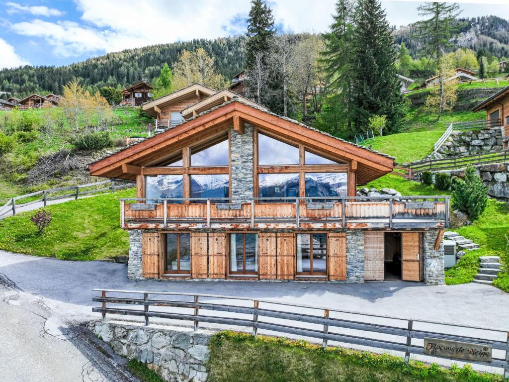 uma casa nas montanhas com uma casa de madeira em Chalet Chalet Flocon de Neige by Interhome em Plan Fey