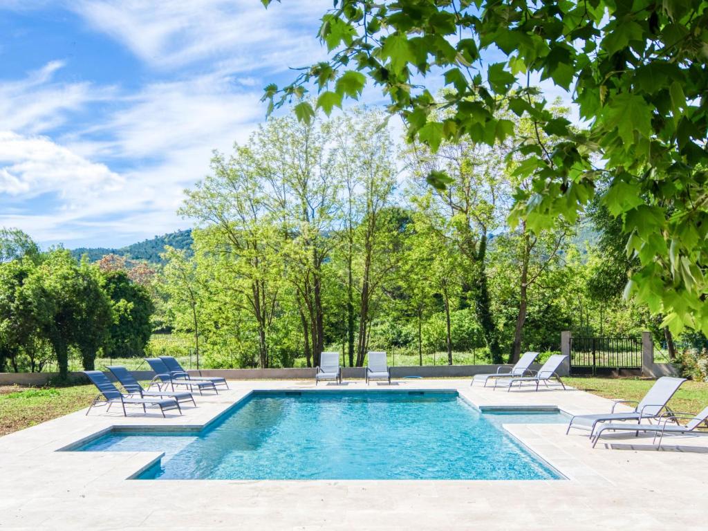 une piscine avec des chaises longues et une piscine dans l'établissement Holiday Home Le Cabanon by Interhome, à Besse-sur-Issole