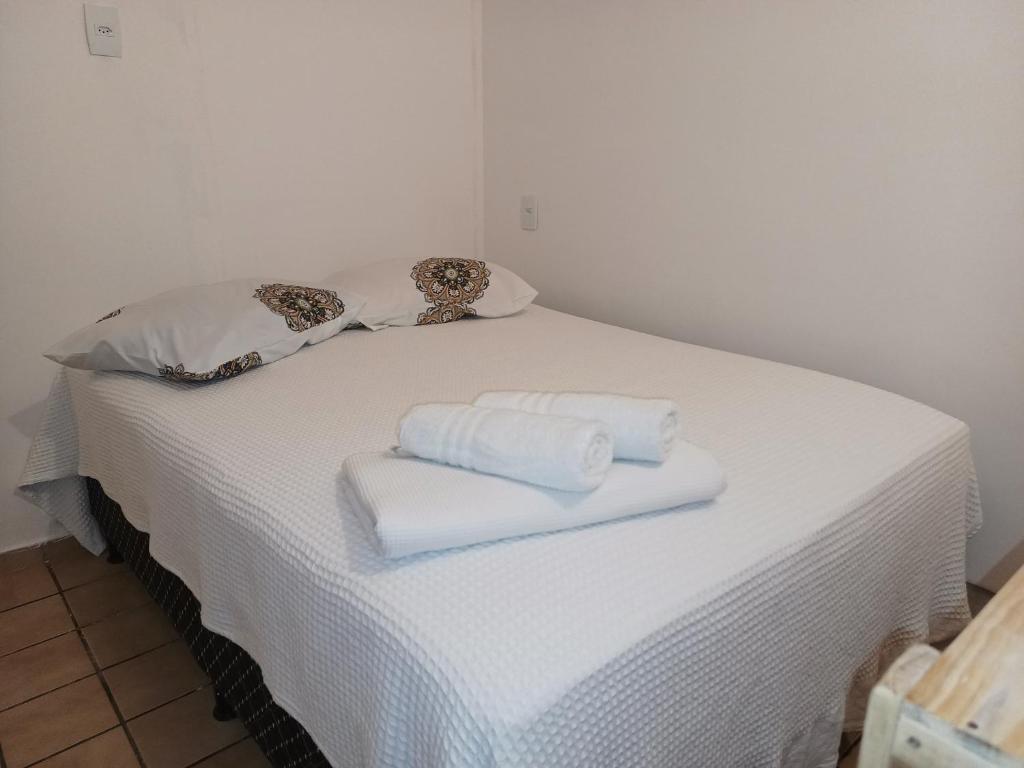 a white bed with two folded towels on it at Pousada Tô na Praia! - 1ª Filial da Tô em Casa em Cabo Branco in João Pessoa
