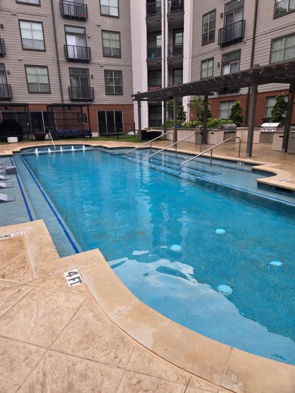 una gran piscina frente a un edificio en Comfortable 1 Bedroom condo en Dallas