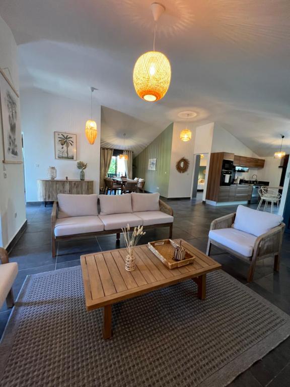 Una sala de estar con un sofá y una mesa de café. en Appartement de charme front de mer, en Saint-Paul