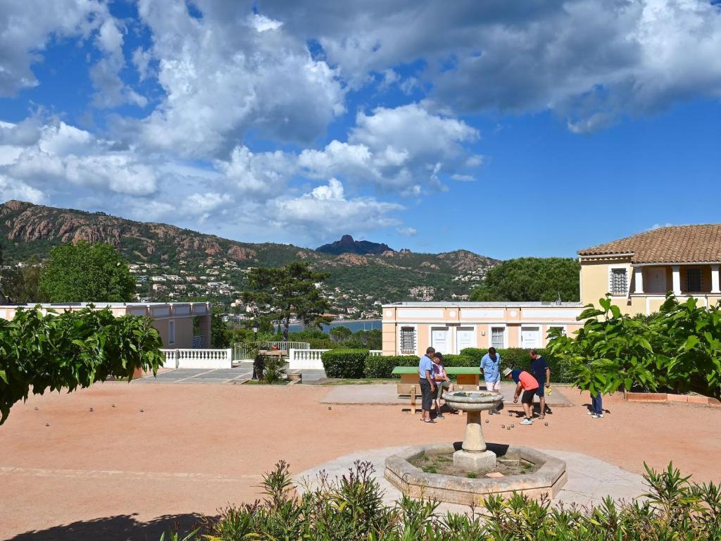 a group of people sitting around a fountain in a courtyard at Apartment Village Cap Estérel - L&#39;Esquinade-23 by Interhome in Agay - Saint Raphael