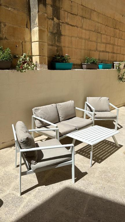 two white chairs and a couch and a table at St Pauls Bay house with 5 bedrooms in St Paul's Bay