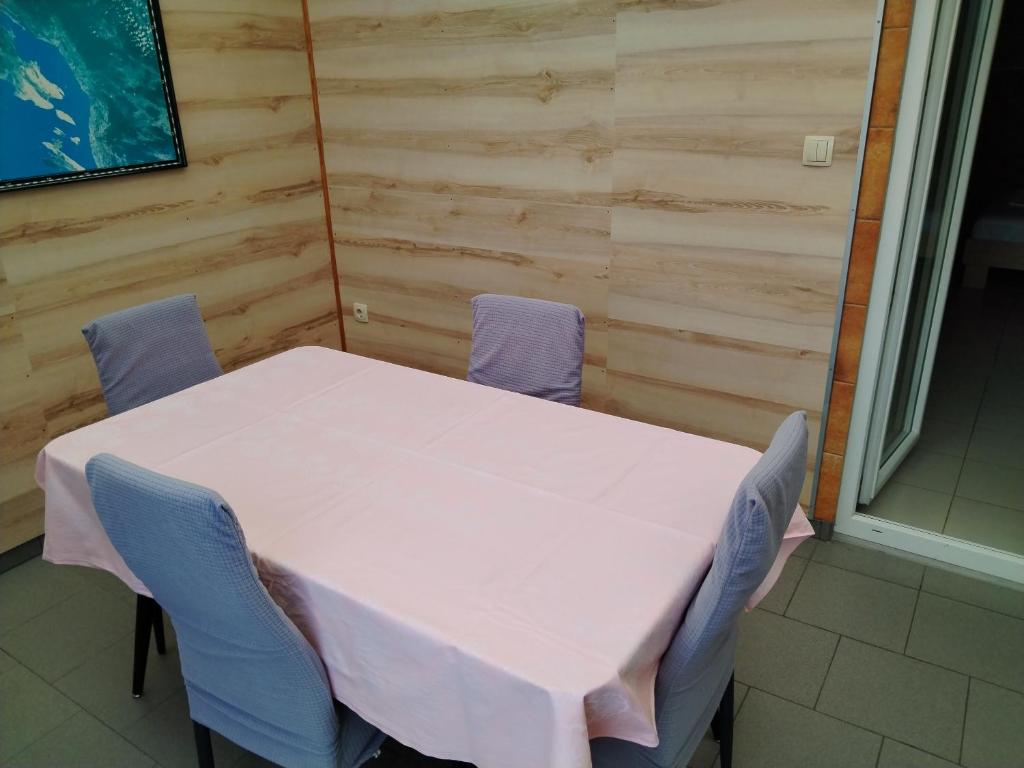 a white table and chairs in a room at Apartmani Marijan in Crikvenica