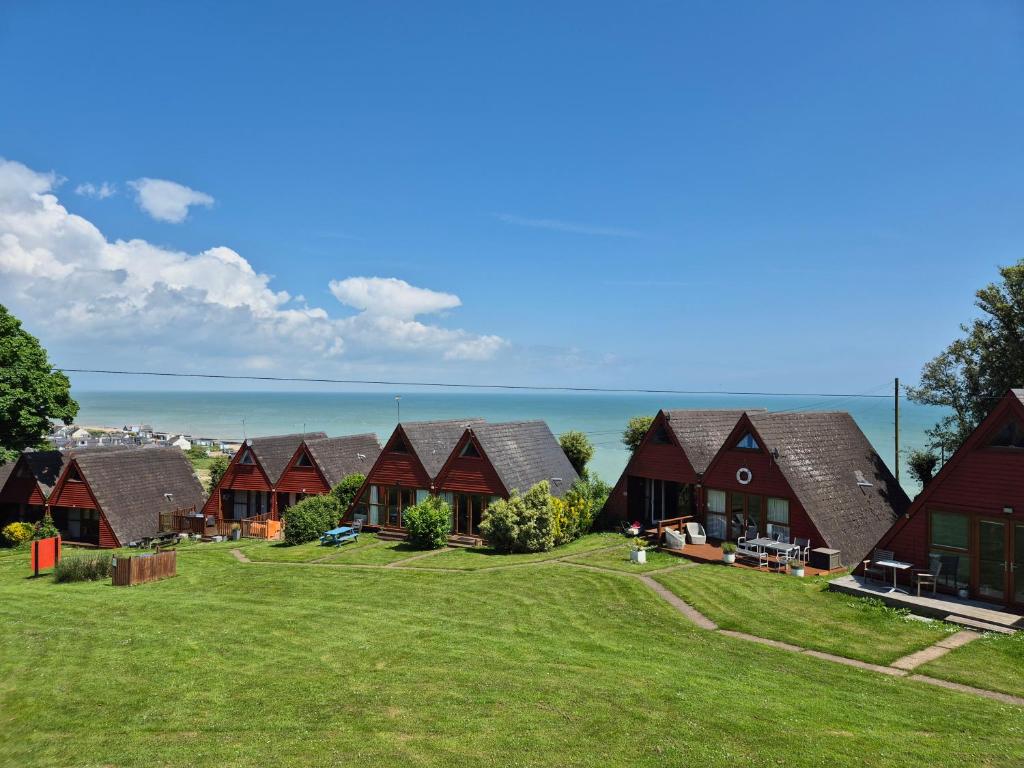 a row of houses with the ocean in the background at WOW! Amazing SEA VIEWS at Coastal chalet in Kingsdown Park with pool No 40 in Kingsdown