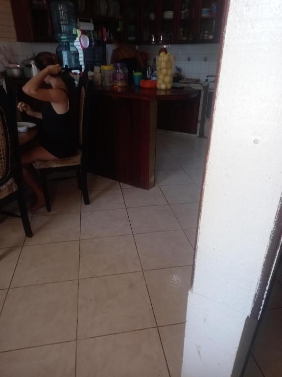 a woman sitting in a chair in a kitchen at Jackson Guest House in Corn Island