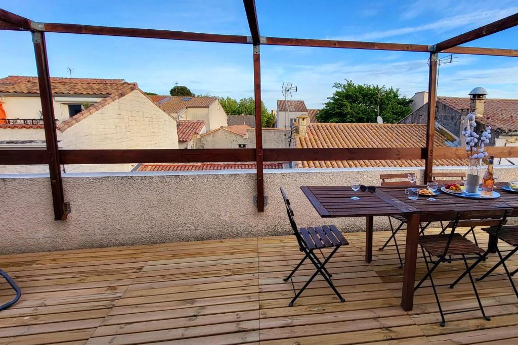 un patio avec une table et des chaises sur un balcon dans l'établissement La Terrasse sur les toits du centre ville à 300m de la plage, au Grau-du-Roi