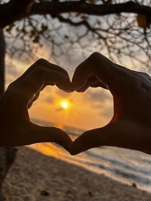 a pair of hands are making a heartshape at Casa Boutique Rincon in San Onofre