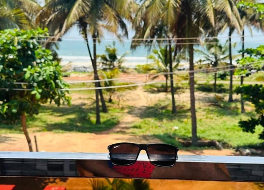 a pair of sunglasses sitting on a bench overlooking the beach at Nenapu Beachfront Mangalore in Mangalore