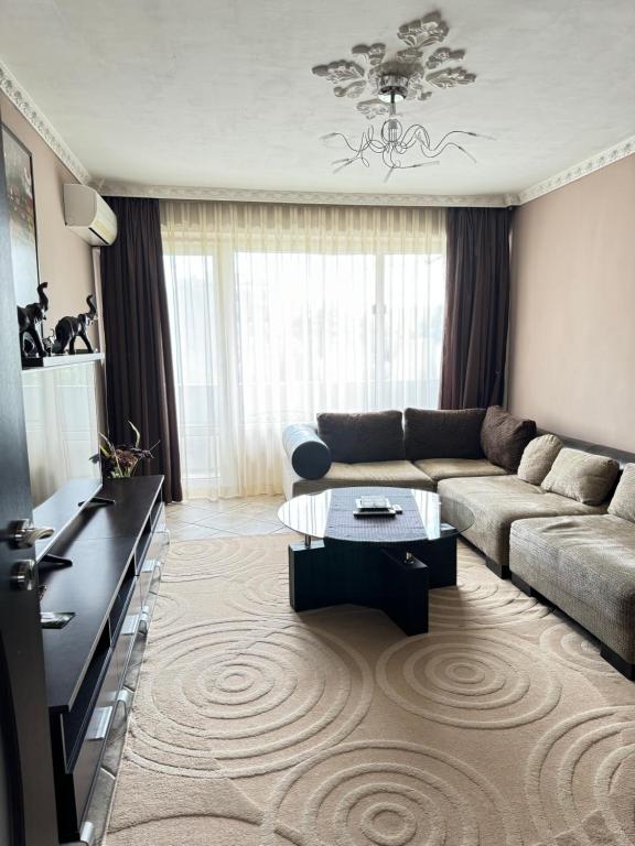 ein Wohnzimmer mit einem Sofa und einem Couchtisch in der Unterkunft Infinity is the best in Burgas City