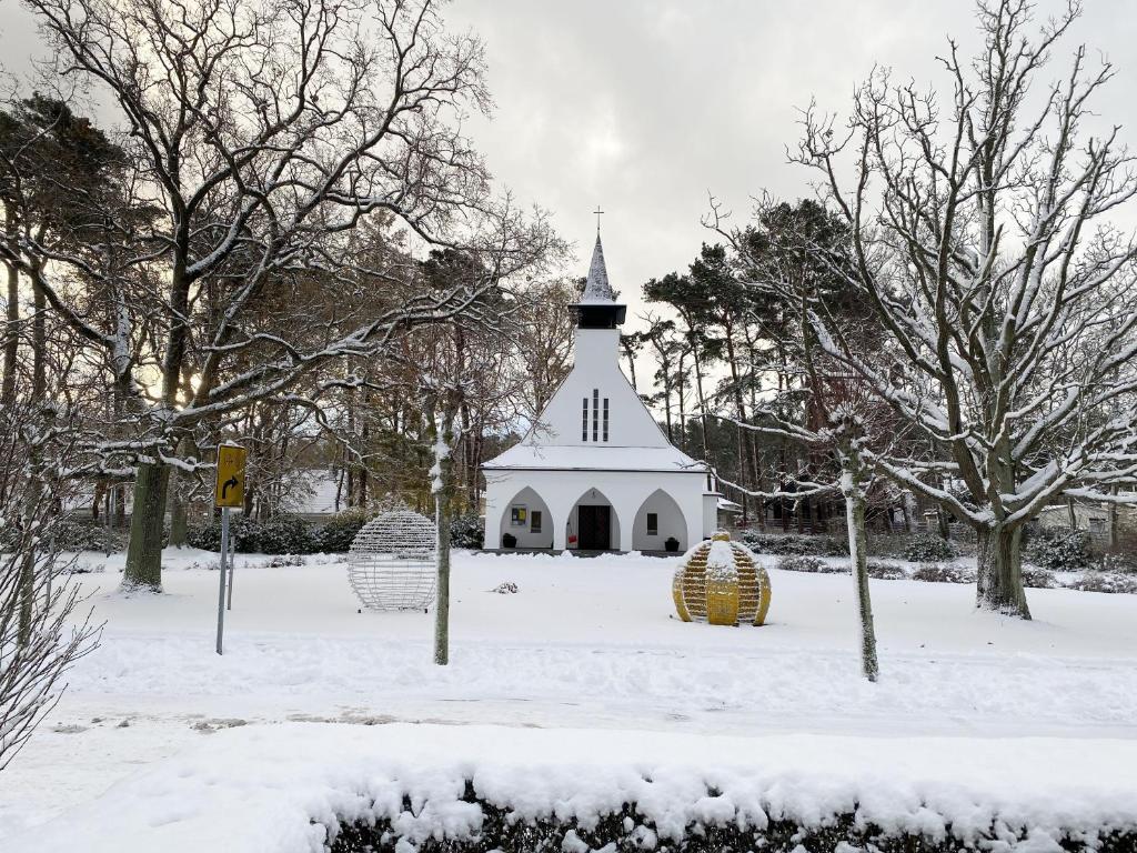 バーベにあるHaus Meeresblick-Ferienwohnung Nordlichtの雪の中に急勾配を持つ白教会