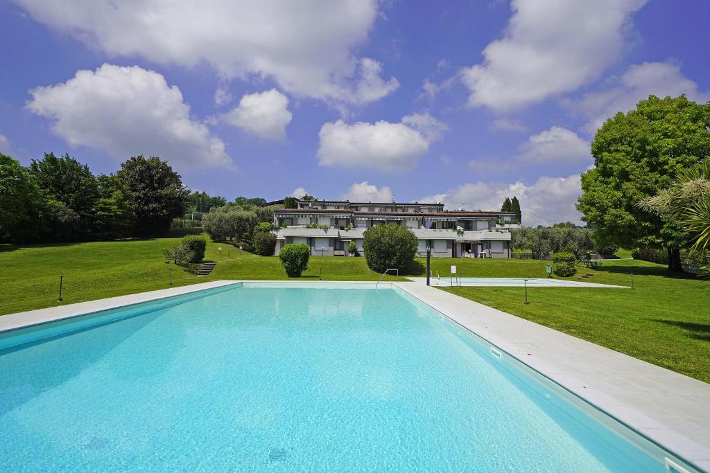 a large swimming pool in front of a house at Petronella - Gardagate in Soiano del Lago