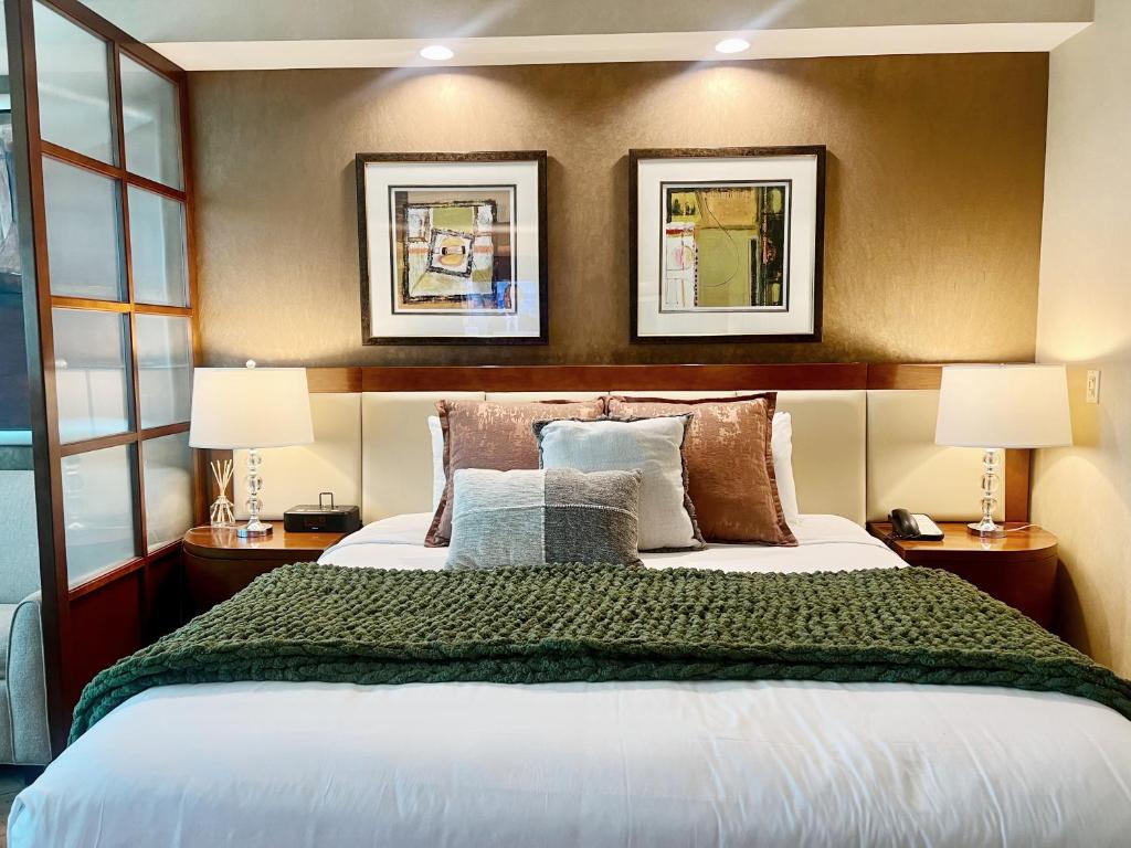 a bedroom with a large bed with two lamps at MGM Studio Suite with POOL VIEW Tower 1 in Las Vegas
