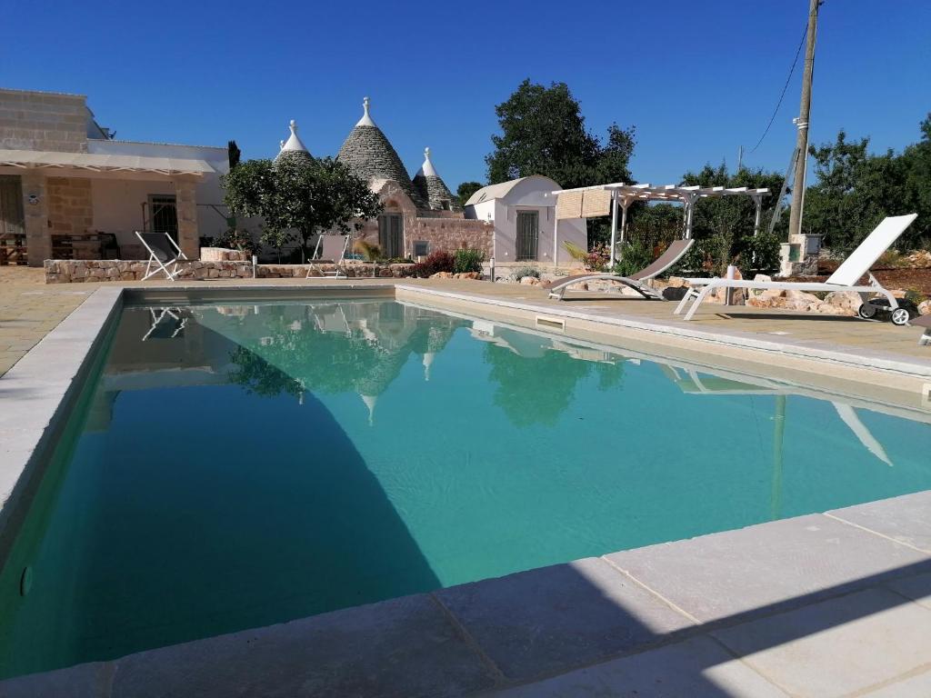 uma grande piscina com água azul em Trullo del Sol em Ceglie Messapica
