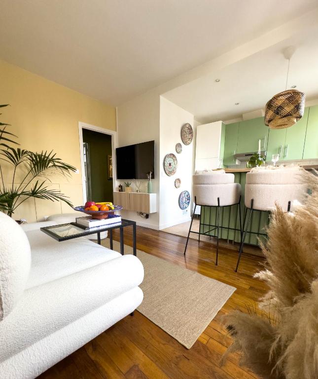 un salon avec un canapé blanc et une cuisine dans l'établissement Appartement La Défense, à La Garenne-Colombes