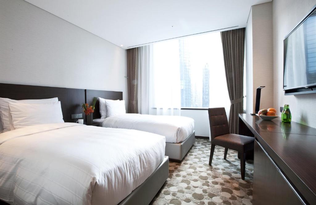Postel nebo postele na pokoji v ubytování LOTTE City Hotel Myeongdong