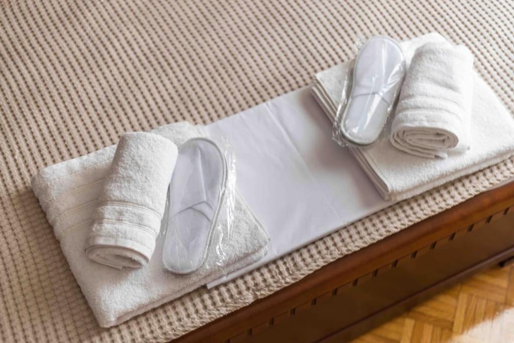 un par de zapatos y toallas en una cama en Center Proluxe Apartment, en Alexandroupoli