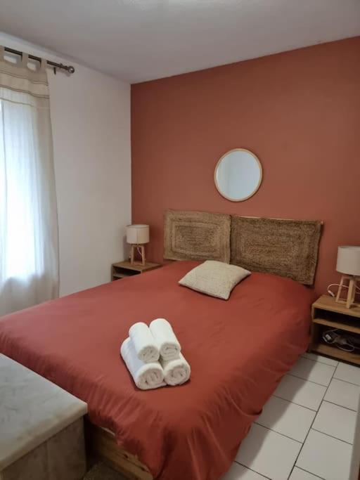 - une chambre avec un lit rouge et 2 serviettes de toilette dans l'établissement T2 Hyper centre rénové + parking, proche Comédie, à Montpellier