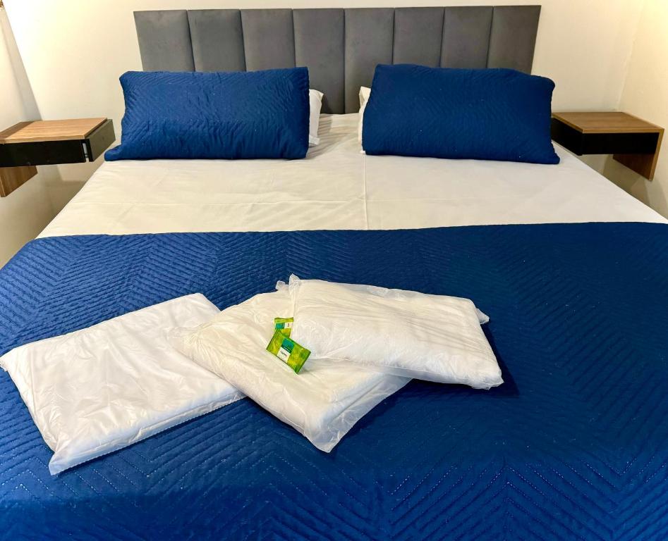Una cama con dos almohadas blancas y una corbata verde. en Rio Deal Guest House, en Río de Janeiro