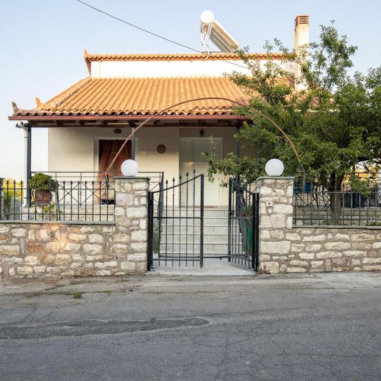 ein weißes Haus mit einem Tor und einer Tür in der Unterkunft Neromilos Harmony - Roussis Residence in Nerómilos