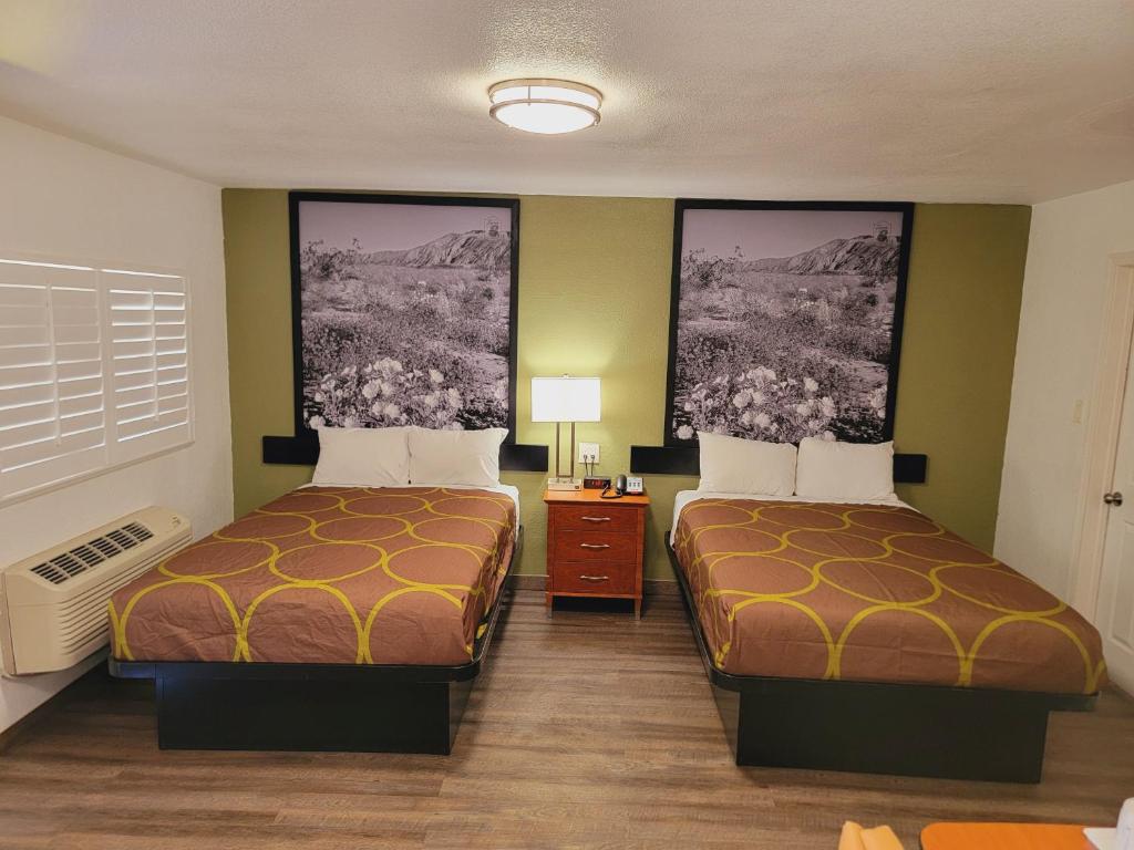 pokój hotelowy z 2 łóżkami i 2 zdjęciami na ścianie w obiekcie Super 8 by Wyndham El Centro North w mieście El Centro