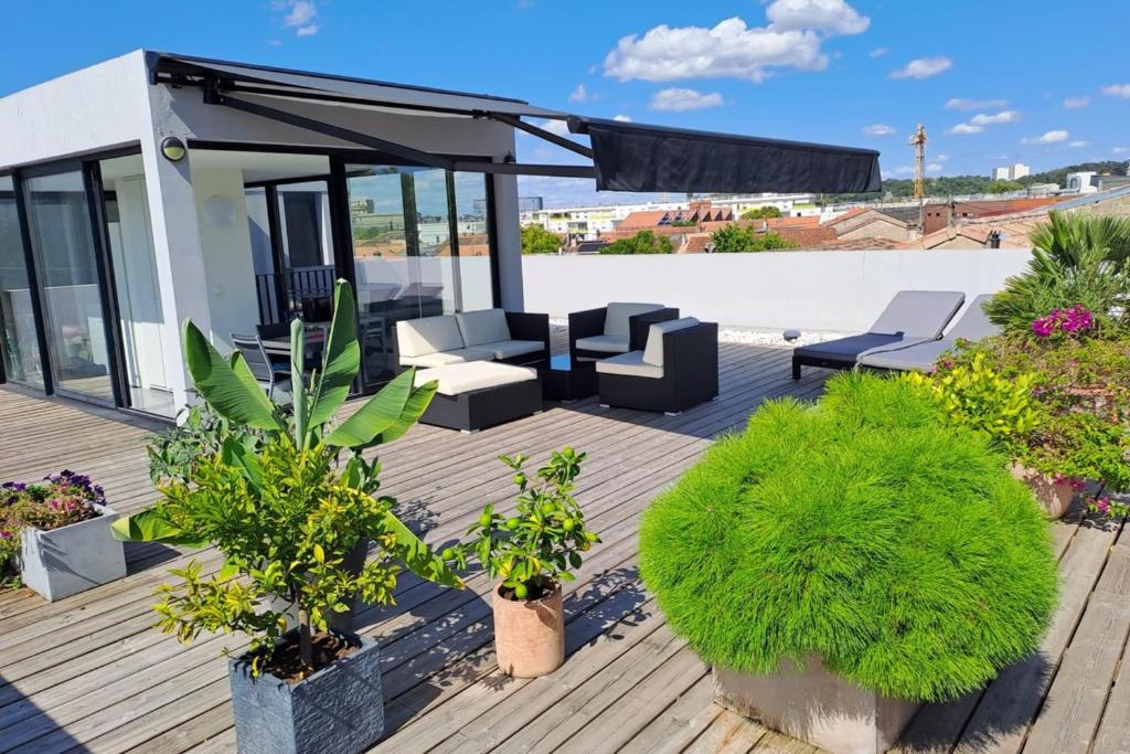 une terrasse avec mobilier et plantes sur une maison dans l'établissement Spacious and bright nest with beautiful terrace, à Bordeaux