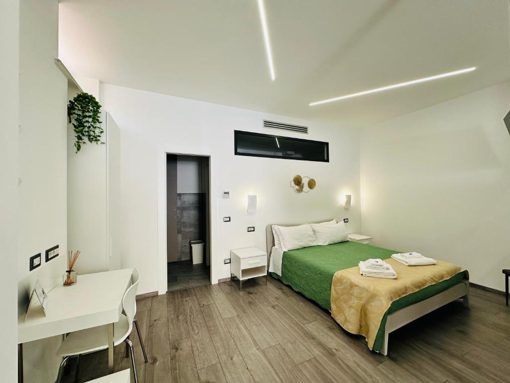 ein weißes Schlafzimmer mit einem grünen Bett und einem Schreibtisch in der Unterkunft San Saba Street Apartment 52 in Rom