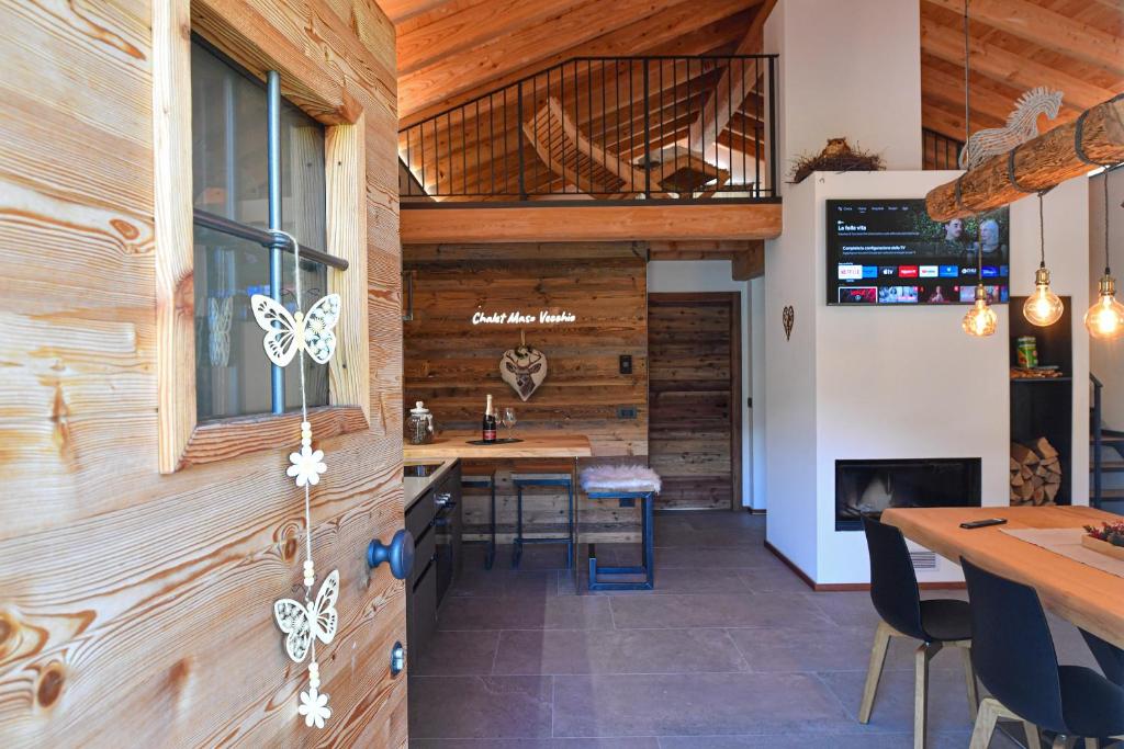 cocina con paredes de madera, mesa y sillas en Chalet Cirmolo - Chalet Maso Vecchio immerso nell'Altopiano del Tesino, Trentino, en Castello Tesino