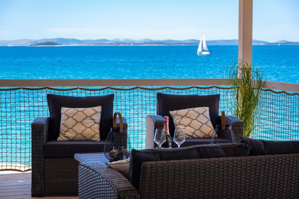 two chairs and a table with a view of the ocean at Luna Maris in Drage