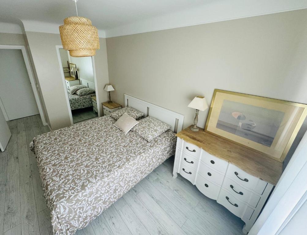 een slaapkamer met een bed, een dressoir en een spiegel bij Cannes, charmant 3 pièces proches plages, tout confort au calme in Cannes