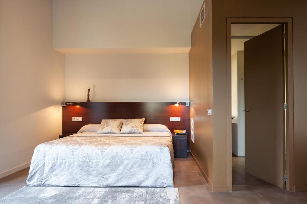 a bedroom with a large bed with a wooden headboard at Casa Marcial (adults only) in Besalú