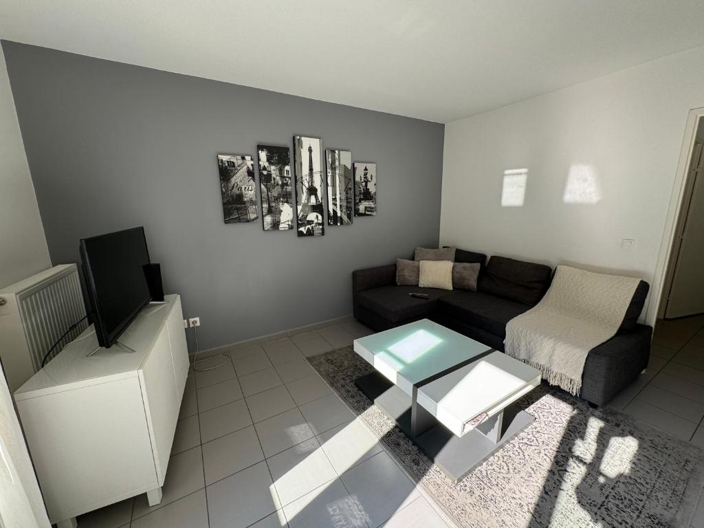 een woonkamer met een bank en een tafel bij Dream Apartments in Serris