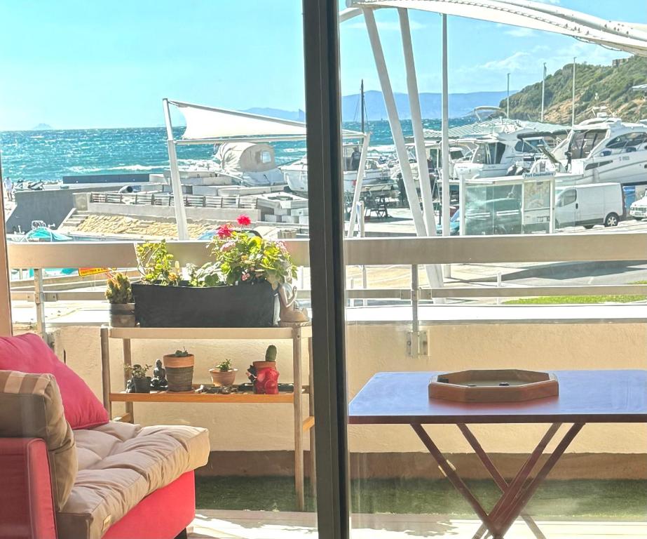 une pièce avec un canapé, une table et un bateau dans l'établissement Appartement en face mer, à Six-Fours-les-Plages