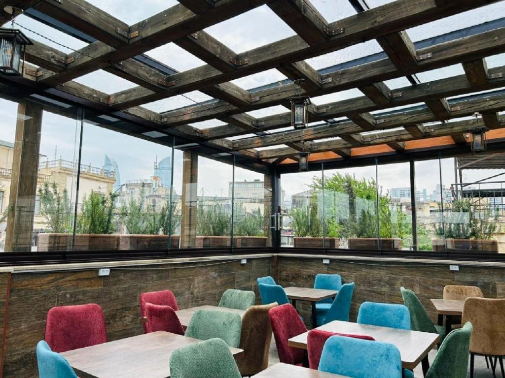 un restaurant avec des tables, des chaises et des fenêtres dans l'établissement Parliament Hotel Baku, à Baku