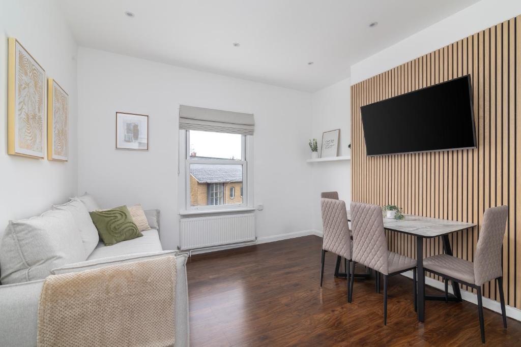倫敦的住宿－Cosy Apartment in Queens Park，客厅配有沙发和桌椅