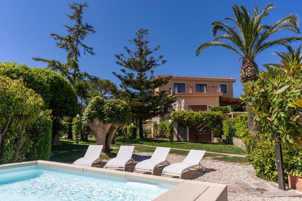 een villa met een zwembad en palmbomen bij Villa Solatia in Massa Lubrense