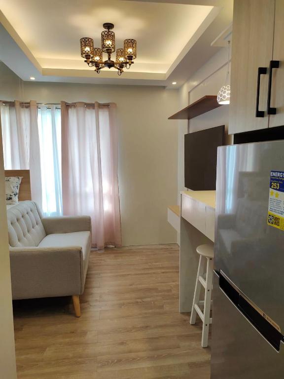 a living room with a couch and a kitchen at Studio Type BNB Accommodation in Bacolod