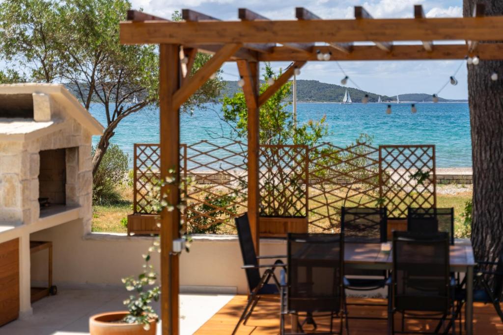 a patio with a table and chairs and a view of the ocean at Villa Serenum in Šibenik