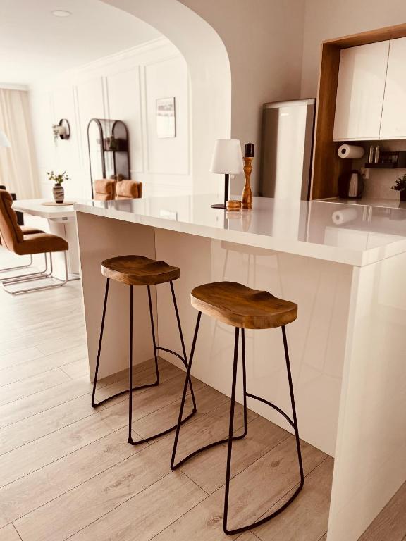 a kitchen with a counter and two stools at Apartament Na Starówce in Kłodzko