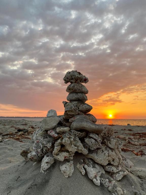 a stack of rocks on the beach at sunset at Dayun La Union, Transient House in San Fernando