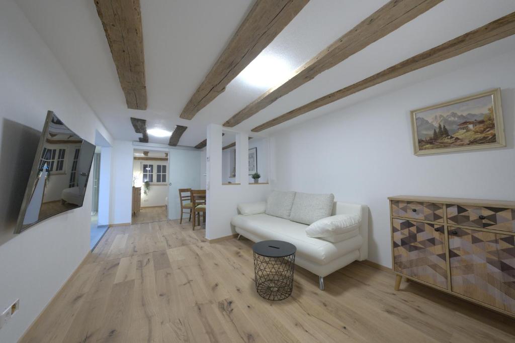 a living room with a white couch and a table at Moderner Altstadt-Diamant in Buchen