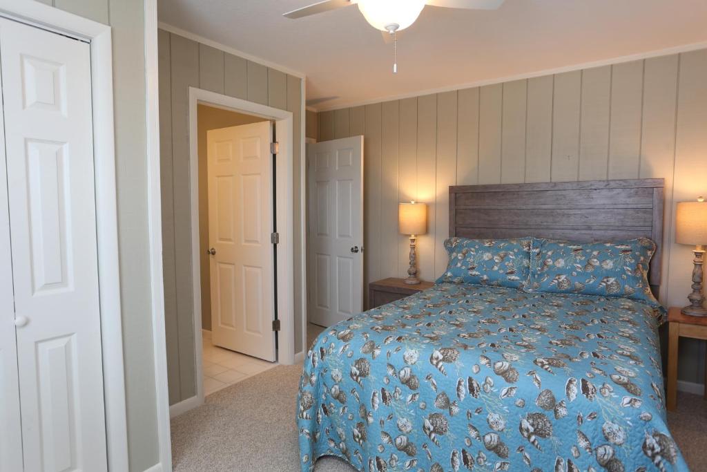 a bedroom with a bed with a blue comforter at One More Time Again by Pristine Properties Vacation Rentals in Mexico Beach