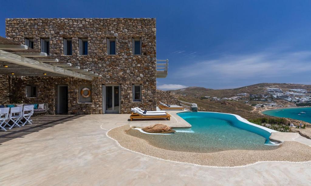 una casa con piscina al lado de un edificio en Lagoon Villa Mykonos, en Mykonos ciudad