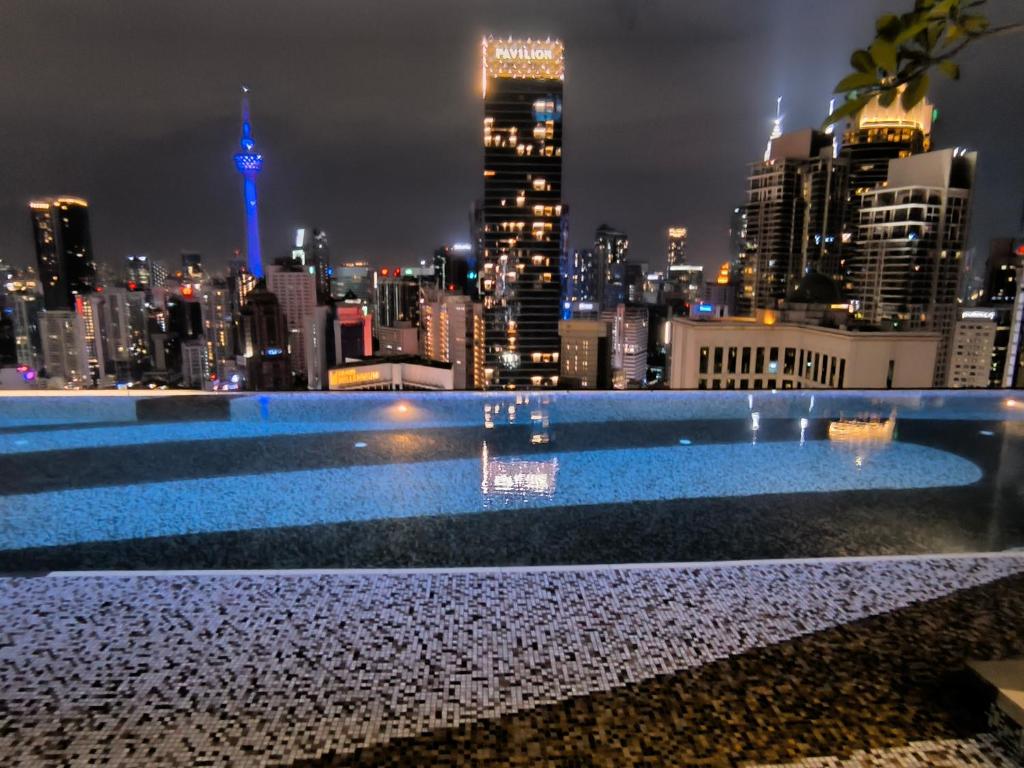 een skyline van de stad 's nachts met een zwembad bij Axon Apartment Bukit Bintang At KL in Kuala Lumpur